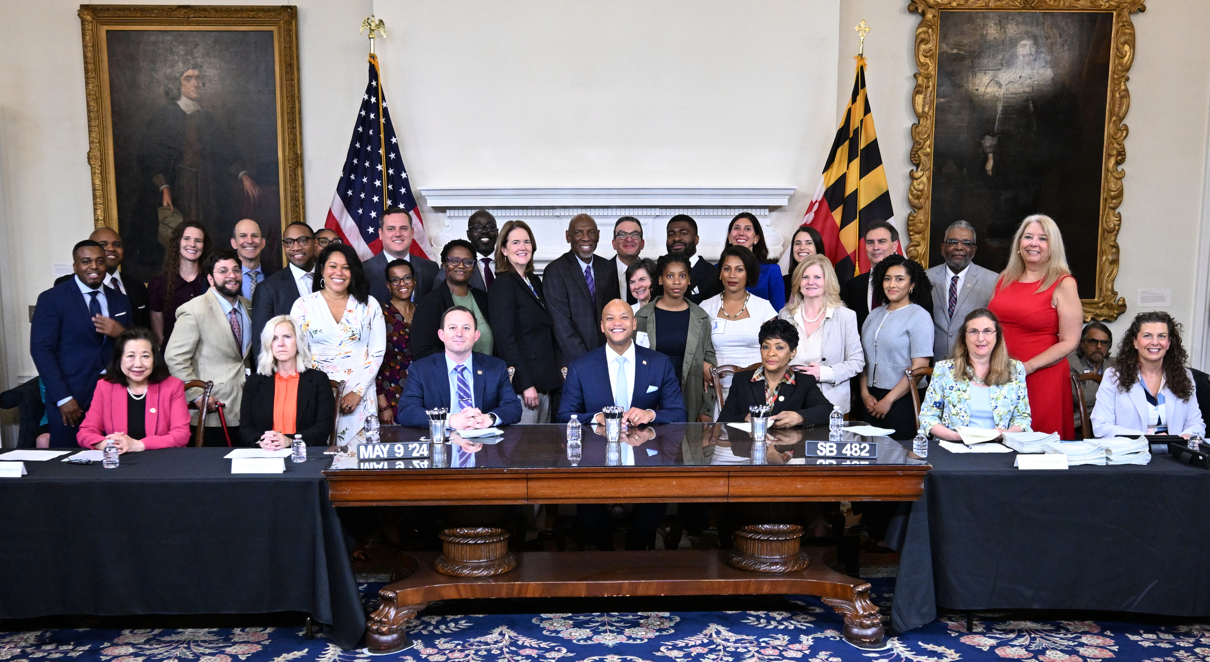 Governor Wes Moore and others sitting at desk for bill signing