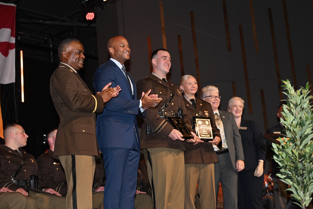 Governor Moore on stage with new Trooper and leadership