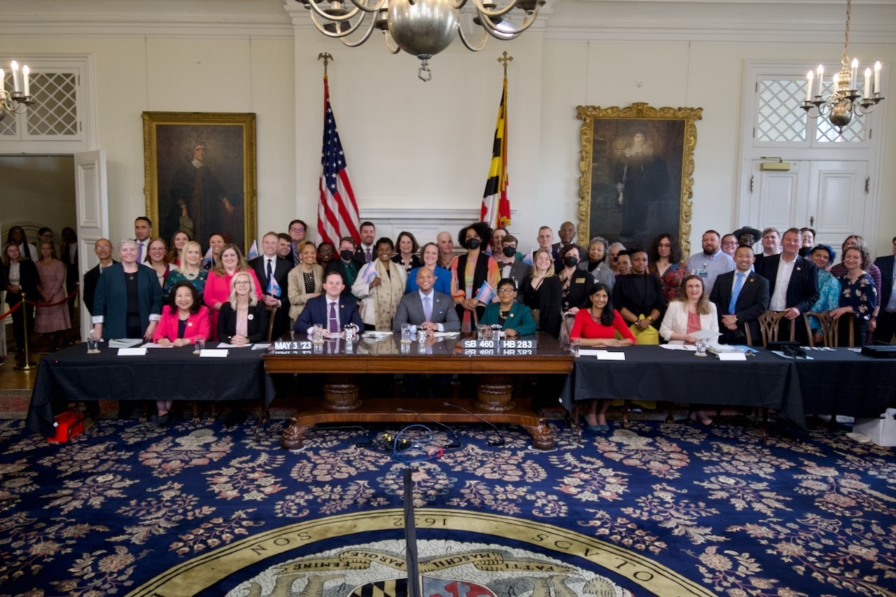 Governor Wes Moore with group of people in Maryland Statehouse Reception Room after bill signing